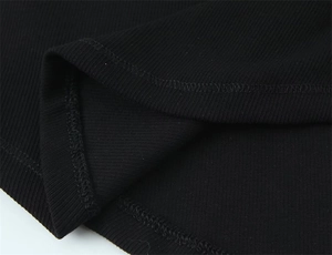 Macro shot of black ribbed cotton fabric detailing vertical texture and fine stitching