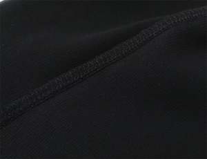 Close-up of fine stitching and black cotton fabric texture on a slim-fit tank top
