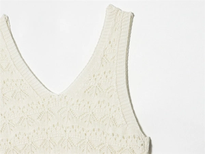 Detailed macro view of white pointelle knit fabric and V-neckline of a stylish dress
