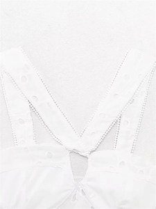 Detail of white cotton top featuring delicate eyelet embroidery and lace trim V-neckline