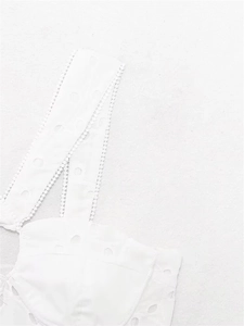 Close-up of white broderie anglaise embroidery and delicate lace trim on the summer set