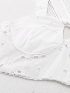 Detail of white cotton eyelet embroidery with delicate crochet trim on a cropped top