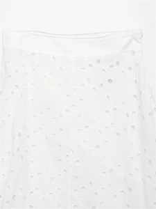 Detailed close-up of white broderie anglaise embroidery on summer skirt waist