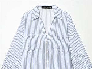 Detailed view of striped shirt collar with chest pockets and woven brand size label