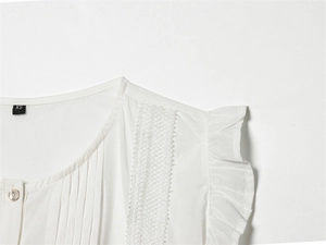 Detailed close-up of white blouse featuring lace lace trim and layered ruffle cuffs