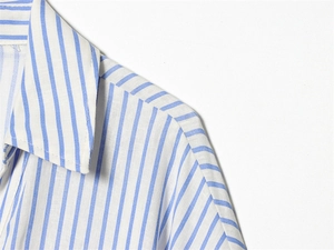 Detail view of the blue and white vertical stripe shirt collar and shoulder stitching
