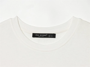 Detail des weißen T-Shirt-Ausschnitts mit Markenetikett und Größeninformationen