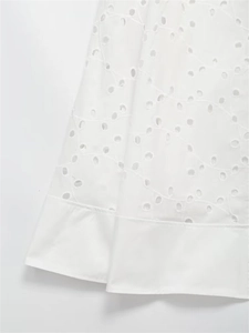 Detailed view of white eyelet embroidery patterns and hem on the summer skirt