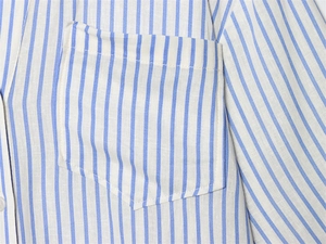 Detail of blue and white vertical striped shirt showing chest pocket and fine stitching