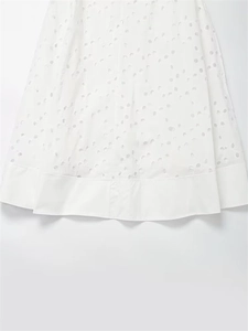Detailed view of white Broderie Anglaise fabric with intricate eyelet embroidery patterns