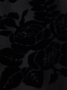 Macro detail of luxurious black velvet fabric featuring 3D rose flower floral patterns