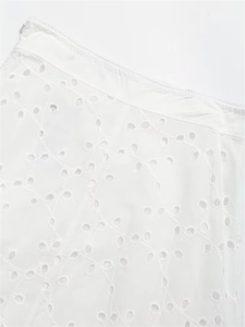 Detailed macro view of white eyelet embroidery fabric with hidden zipper closure