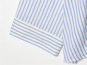 Detail of blue and white striped shirt cuff showing high quality stitching and texture