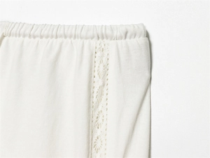 Detail der weißen Baumwollhose mit elastischem Bund und filigranem floralen Spitzensaum