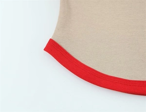 Detailed close-up of light khaki knit fabric with red ribbed trim and precise double stitching