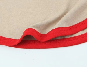 Detailed macro shot of khaki knit T-shirt hem with contrast red ribbed trim and stitching