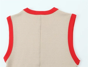 Detail of khaki knit top featuring contrast red ribbed trim and stitching on neckline