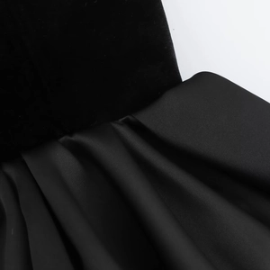 Makrodetail der eleganten Naht aus Samt und plissiertem Satin am schwarzen Oberteil