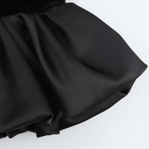 Nahaufnahme der schwarzen Samtstoffstruktur mit eleganten Rüschenfalten und Details