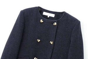 Détail de l'encolure d'une veste en tweed marine avec boutons dorés texturés élégants