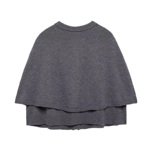 Détail d'un poncho en tricot gris foncé avec col rond et texture à couches superposées