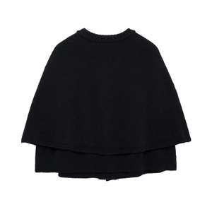 Gros plan détaillé sur cape en maille noire avec texture de laine fine et col rond