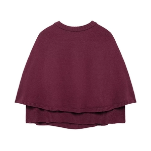 Gros plan du poncho en maille rouge bordeaux avec col rond côtelé et texture douce