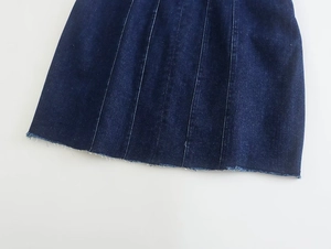 Detalle del vestido vaquero azul oscuro con costuras verticales y dobladillo deshilachado