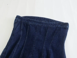 Detalle de vestido denim azul oscuro con costuras verticales princesa para ajuste ceñido