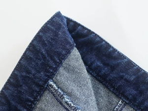 Primer plano de tela vaquera azul oscuro con textura de sarga y costuras de alta calidad