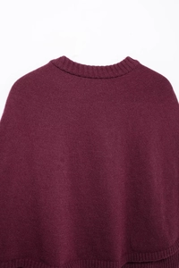 Détail du châle en maille bordeaux montrant le col rond côtelé et la texture du tissu