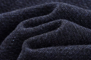 Vue macro détaillée de la texture et des fibres du tricot en laine mélangée bleu foncé
