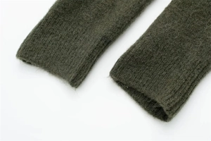Close-up of olive green knitted cardigan cuff showing high-quality wool texture