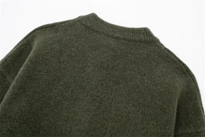 Close-up of olive green knit cardigan showing ribbed neckline and soft wool texture