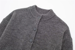 Detailed view of dark grey wool cardigan featuring matte buttons and soft plush texture