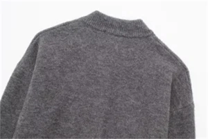 Detailed close-up of dark grey knitted cardigan featuring a classic round neckline and soft texture
