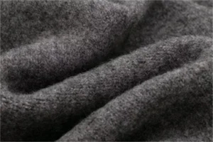 Detailed macro view of dark grey heavy wool fabric texture and soft fuzzy fibers