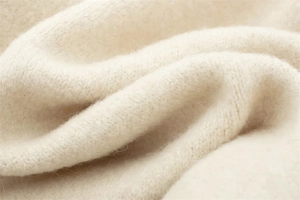 Close-up of soft beige knitted fabric texture with premium wool fibers for women sweaters