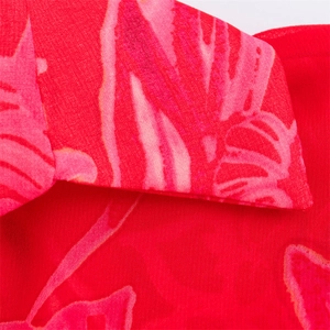 Detail of red floral chiffon fabric showing high-quality stitching and tropical print