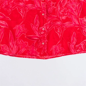 Detail of red floral print chiffon shirt showing white buttons and sheer lightweight fabric