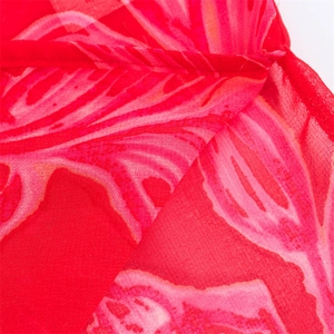 Detailed close-up of red floral chiffon fabric showing seams and translucent texture