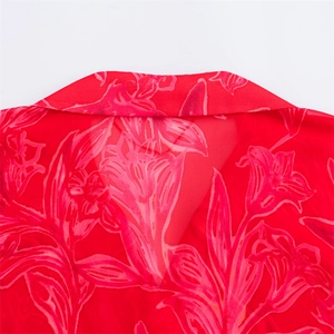 Close-up detail of the lapel collar and floral print on red transparent chiffon shirt