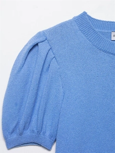 Macro shot of light blue knit top featuring ribbed crew neck and puff sleeve detailing