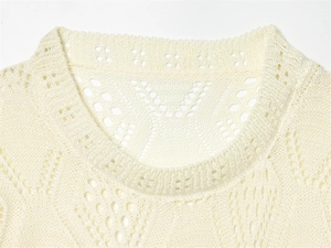 Detail of off-white pointelle knit sweater featuring ribbed neckline and hollow texture