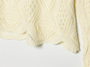 Close-up of the delicate diamond hollow-out knit texture on a beige spring sweater