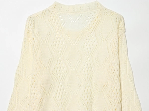 Detail view of the intricate diamond hollow knit pattern and wavy texture on the sweater