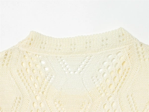 Detail of off-white hollow knit fabric with geometric diamond crochet patterns on neckline