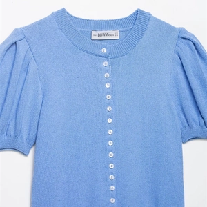 Light blue short sleeve knit cardigan with puff sleeves and white pearl buttons