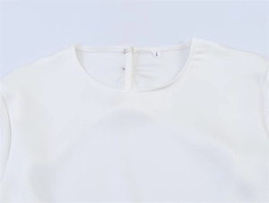 Detail der weißen Satin-Asymmetrie-Oberteil mit Rundhalsausschnitt und Größe S Etikett