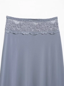 Dettaglio dell'elegante pizzo ampio su una gonna di raso blu polvere dal finish setoso